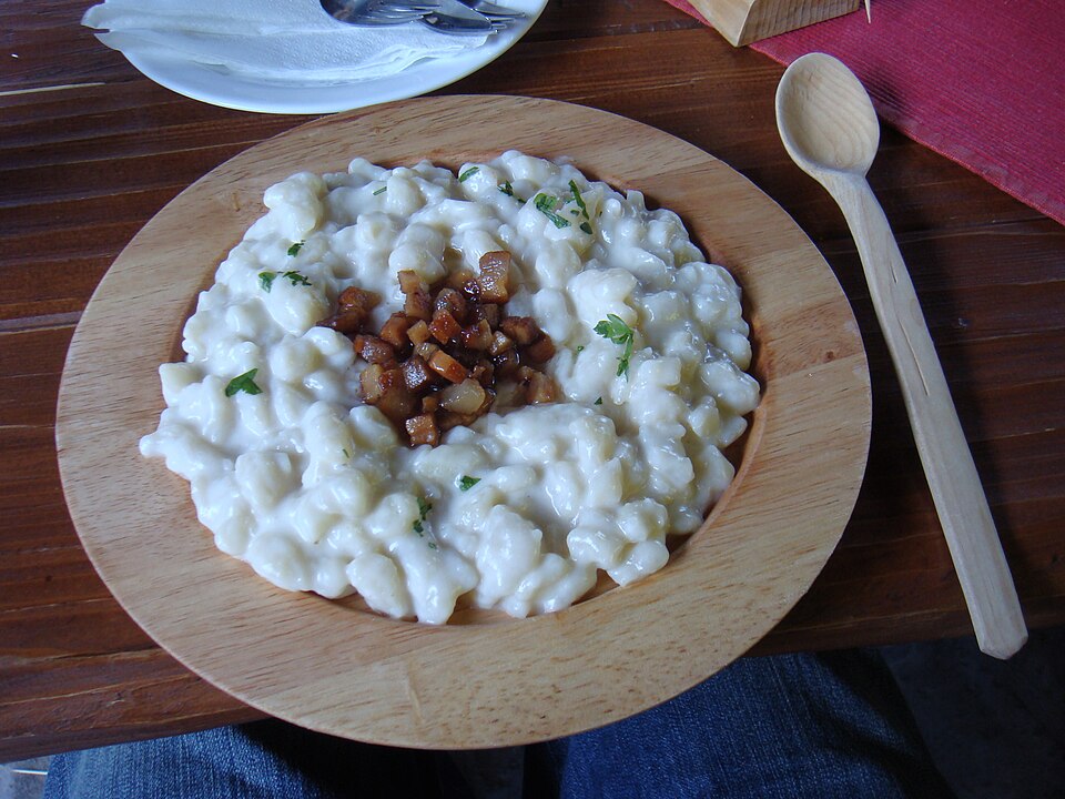 Une assiette de bryndzové halušky, gnocchis de pomme de terre au fromage de brebis et lardons.